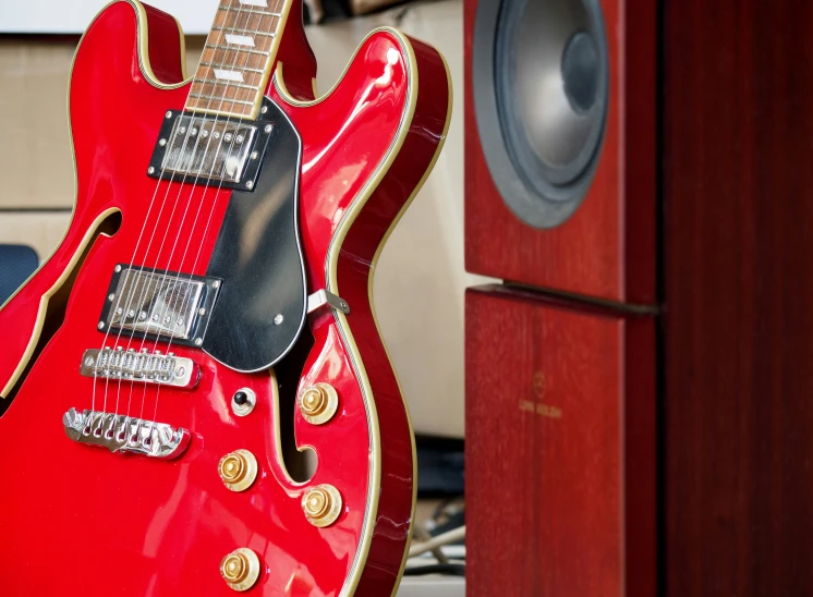 a guitar being held by a pair of speakers