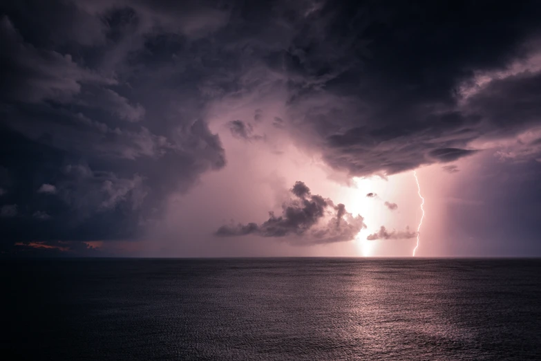 a thunder storm coming over the ocean with rain