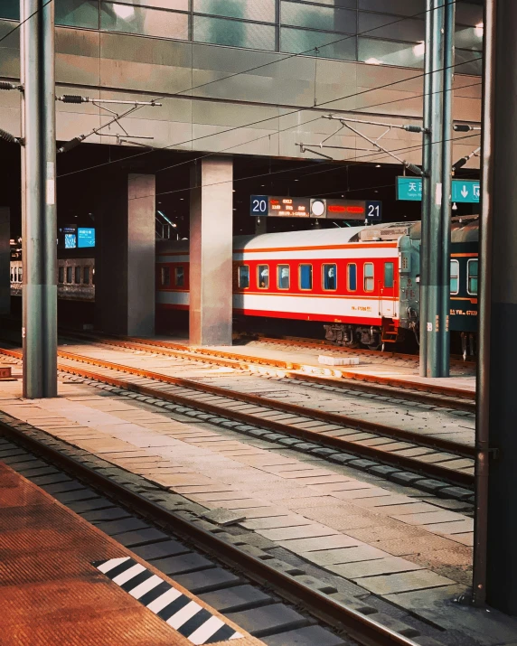 the red passenger train is on the tracks