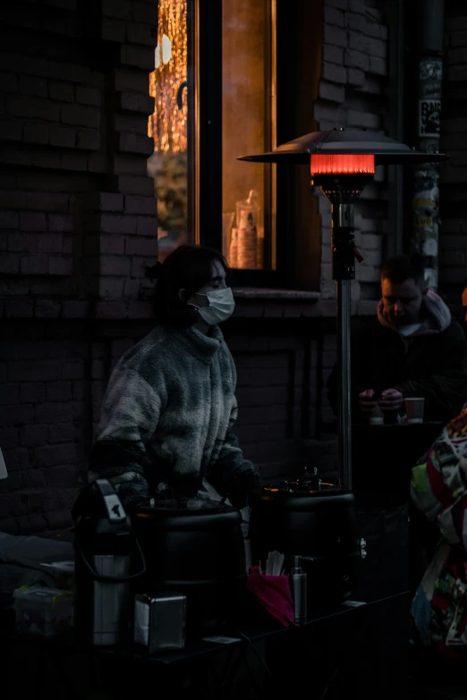 a woman wearing a mask is at a street vendor