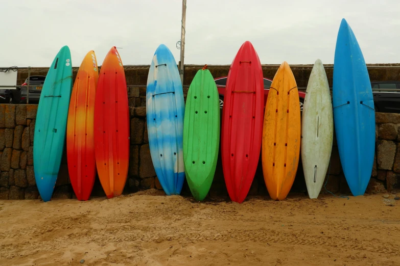 seven surfboards lined up behind a concrete wall