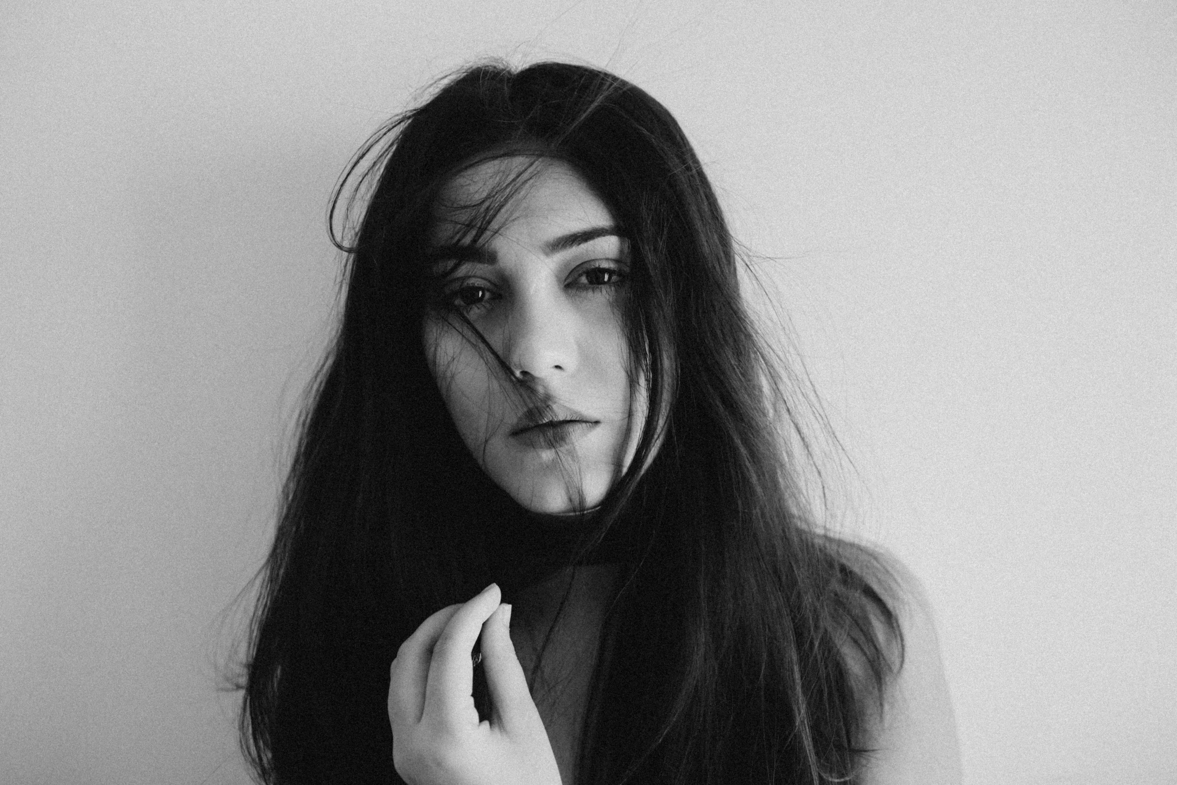 a woman posing with long black hair holding an object in her hands