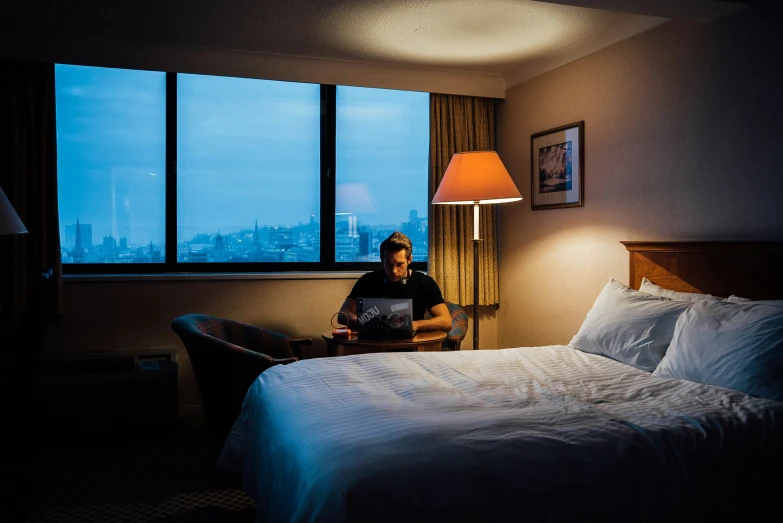 a person on a bed looking out at the city