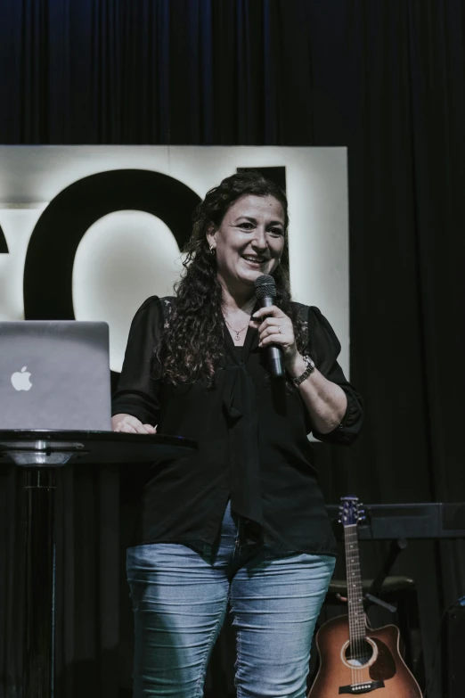 a woman on a stage holding a microphone