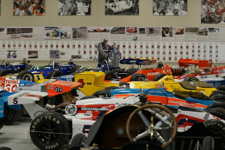 a room filled with some old racing cars and other model cars