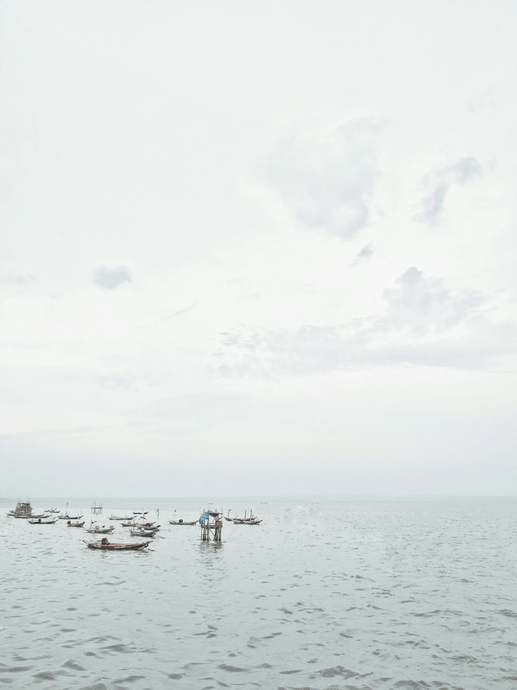 several small boats floating on top of a large body of water