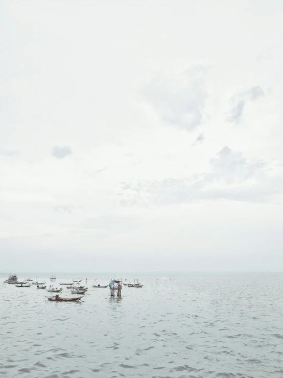 several small boats floating on top of a large body of water