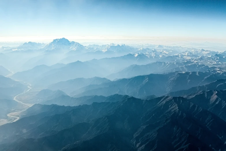 view from the plane window showing some snow covered mountains