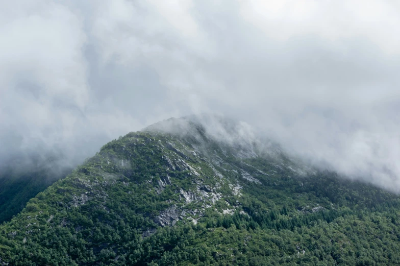 a mountain in the distance, with low cloud formations