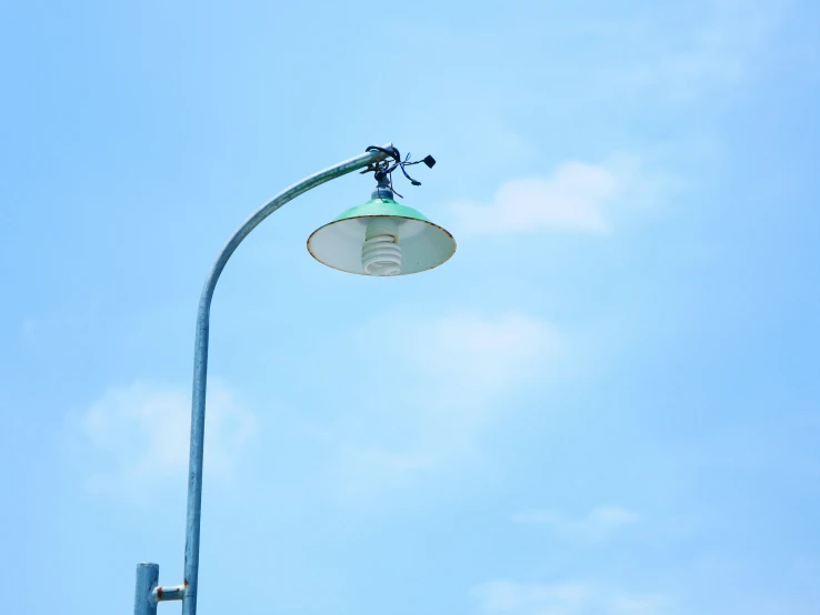 the street light is attached to the blue metal pole