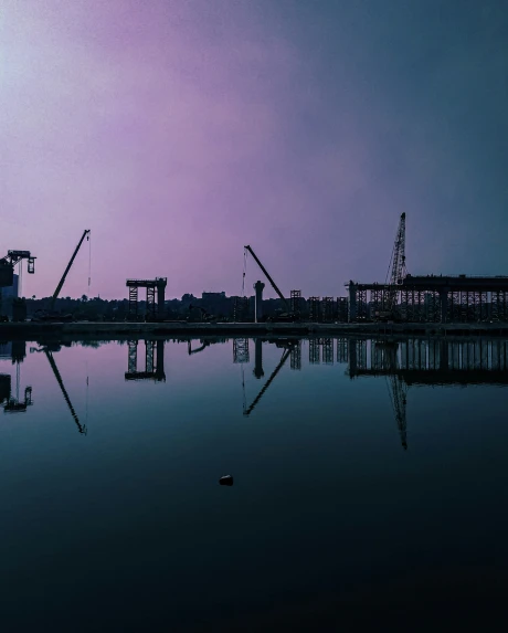 some cranes sit above the water at night