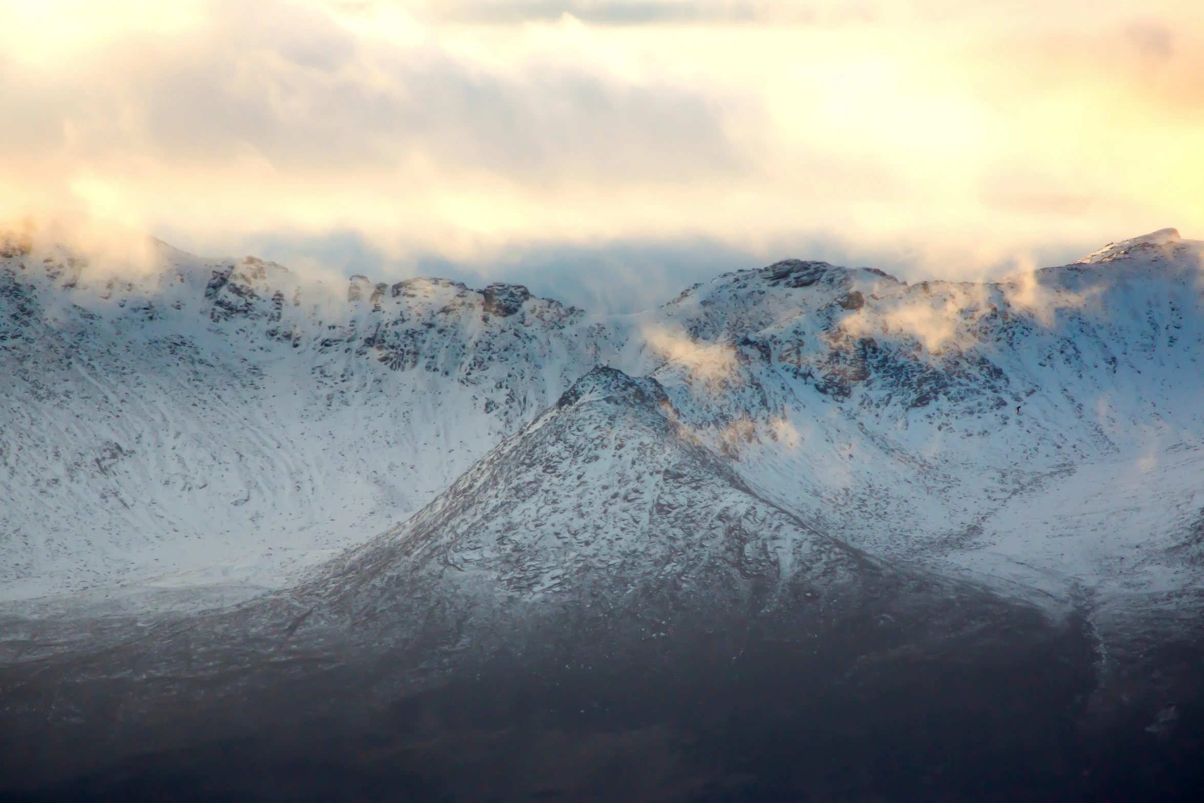 the tops of snowy mountains with sky in background