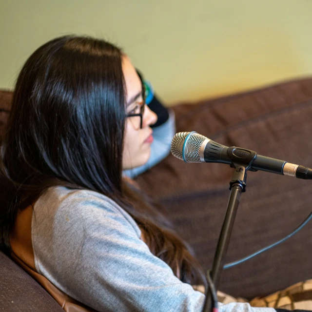 a young woman plays the piano and sings