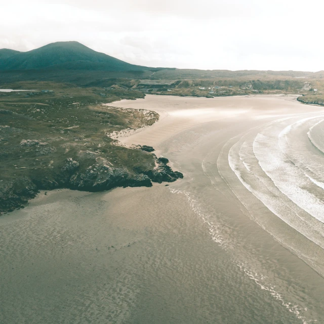 an aerial po of a wide sandy beach