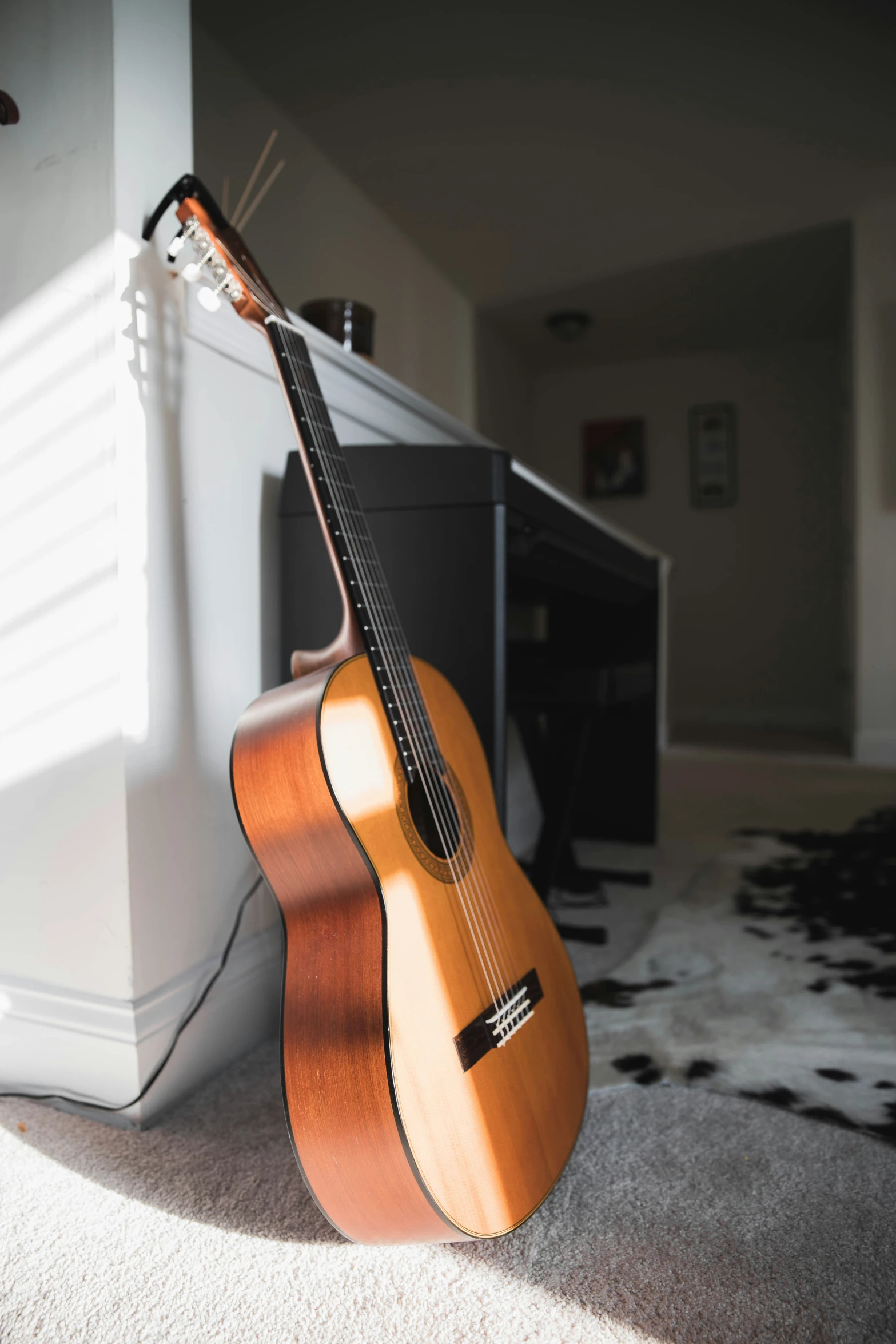 a small wooden guitar resting against a wall