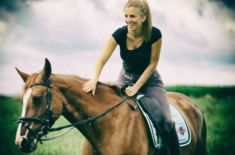 a woman smiling and riding on the back of a horse