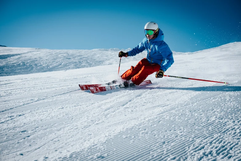person snow skiing down a snowy slope on a clear day