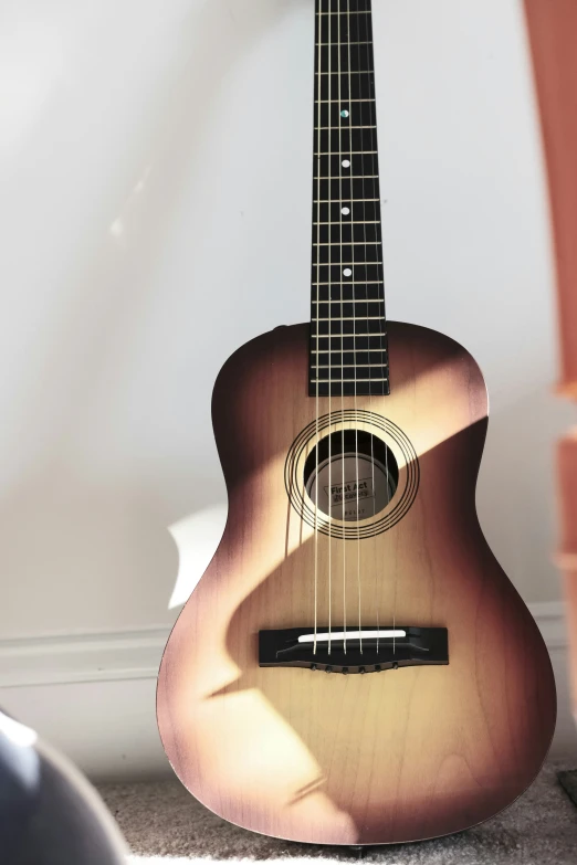 an acoustic guitar is sitting on the floor