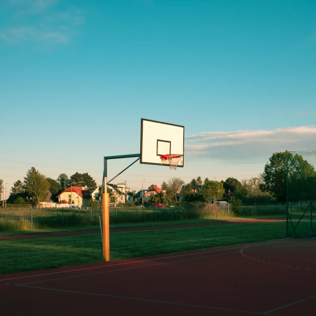 a basketball hoop on a basketball court near a park