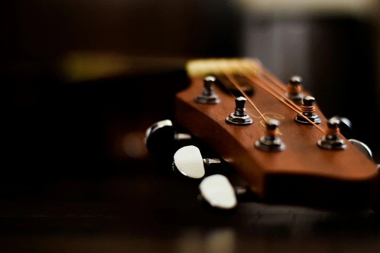 a black guitar is laying on a brown table