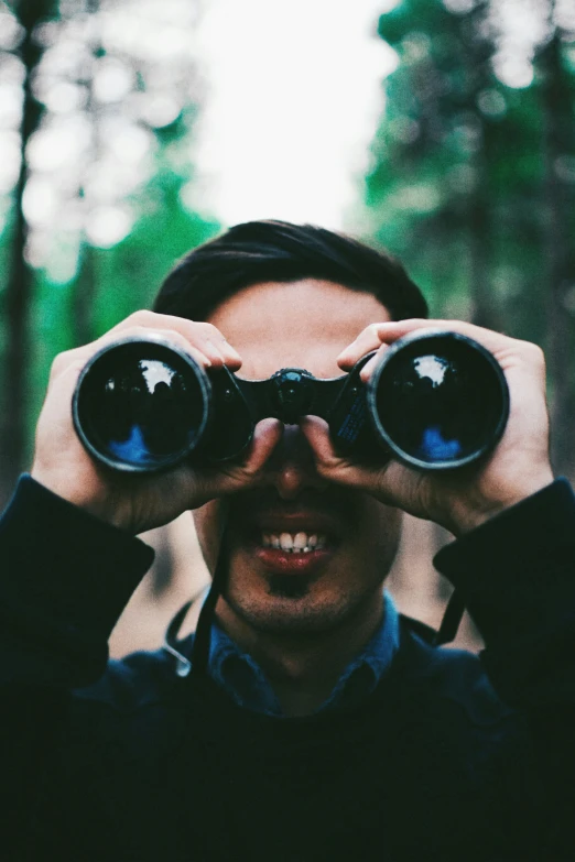 the man is looking through two binoculars