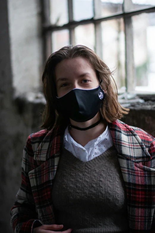 a person in plaid jacket and black mask