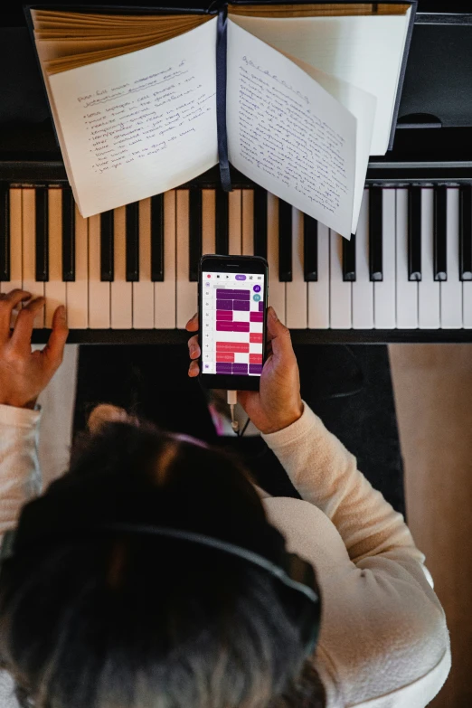 the woman is using her cell phone while looking at the music