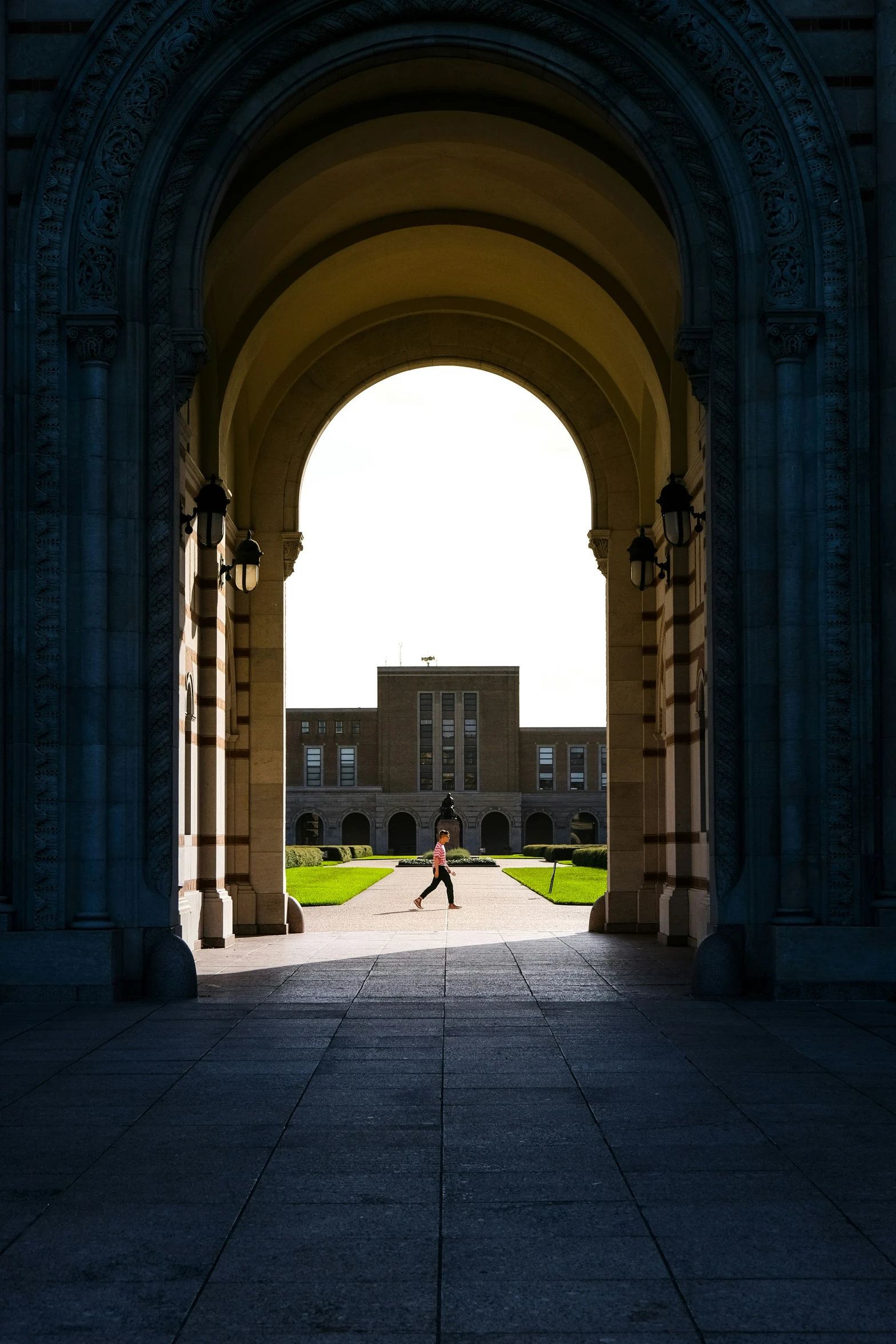 a large arched stone building with a man sitting in the middle of it