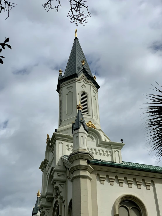 a building with a spire has a palm tree