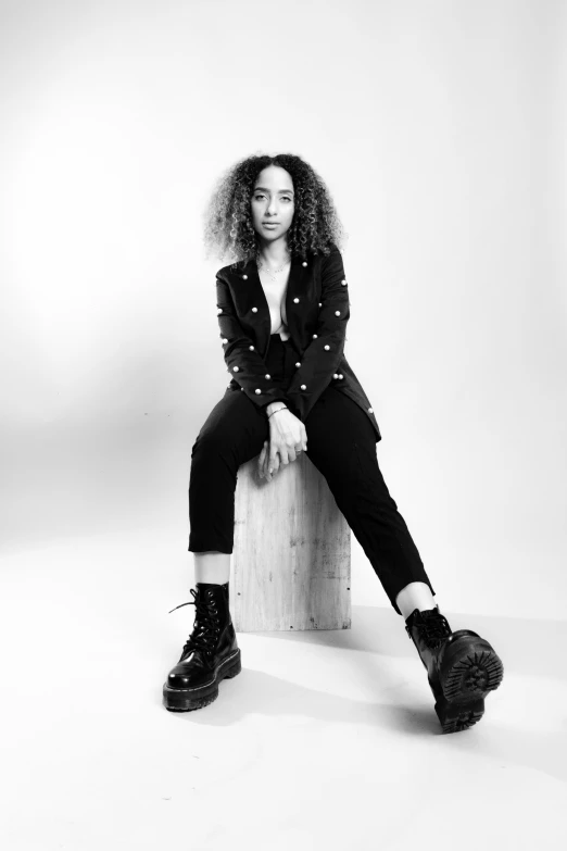 a young black woman sitting on a wooden box