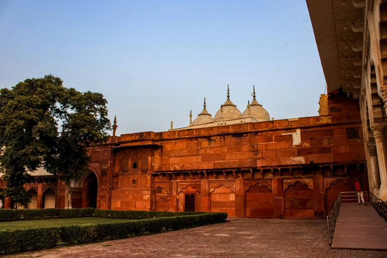 an old building with a long red brick wall with four domes