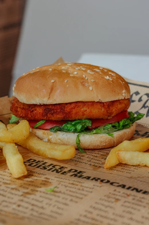 a fried chicken sandwich sitting next to french fries