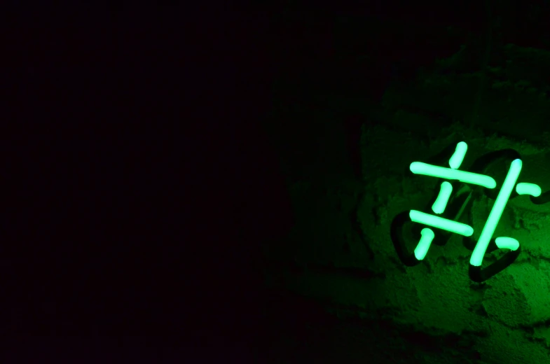 green neon letters in a dark area