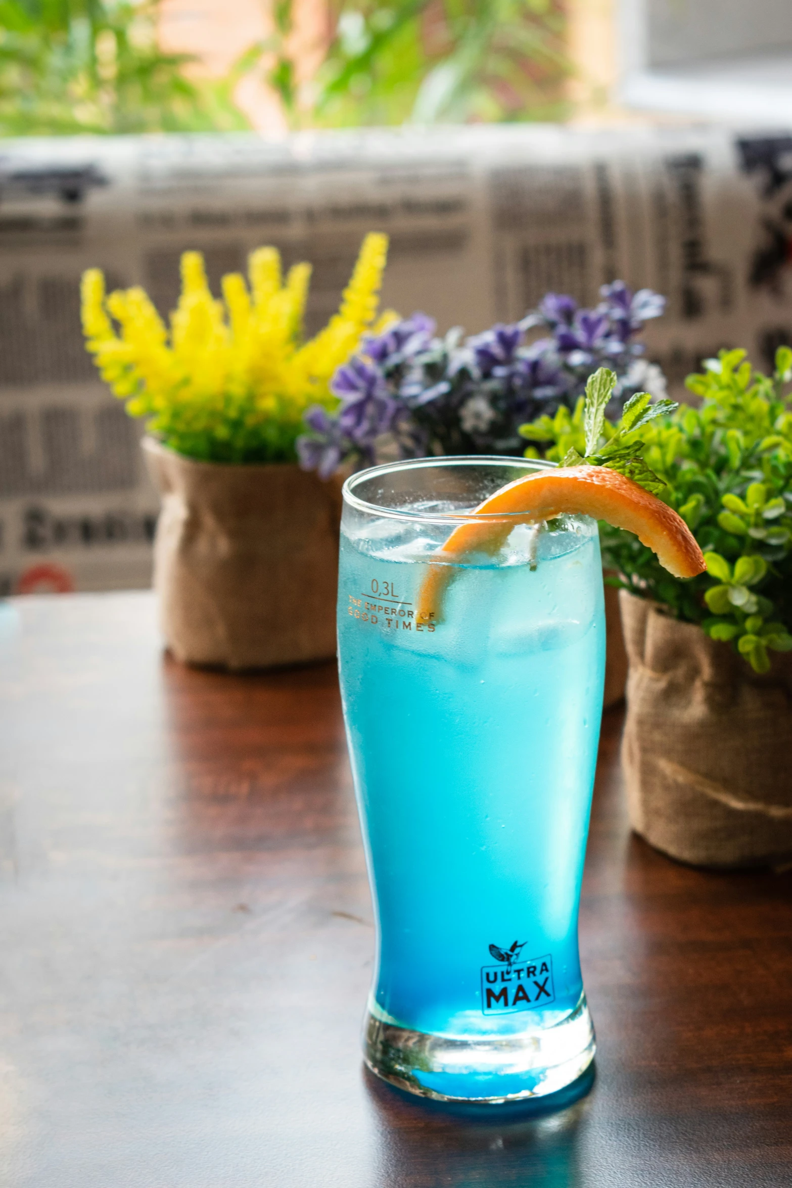 blue drink with orange slice sitting on table