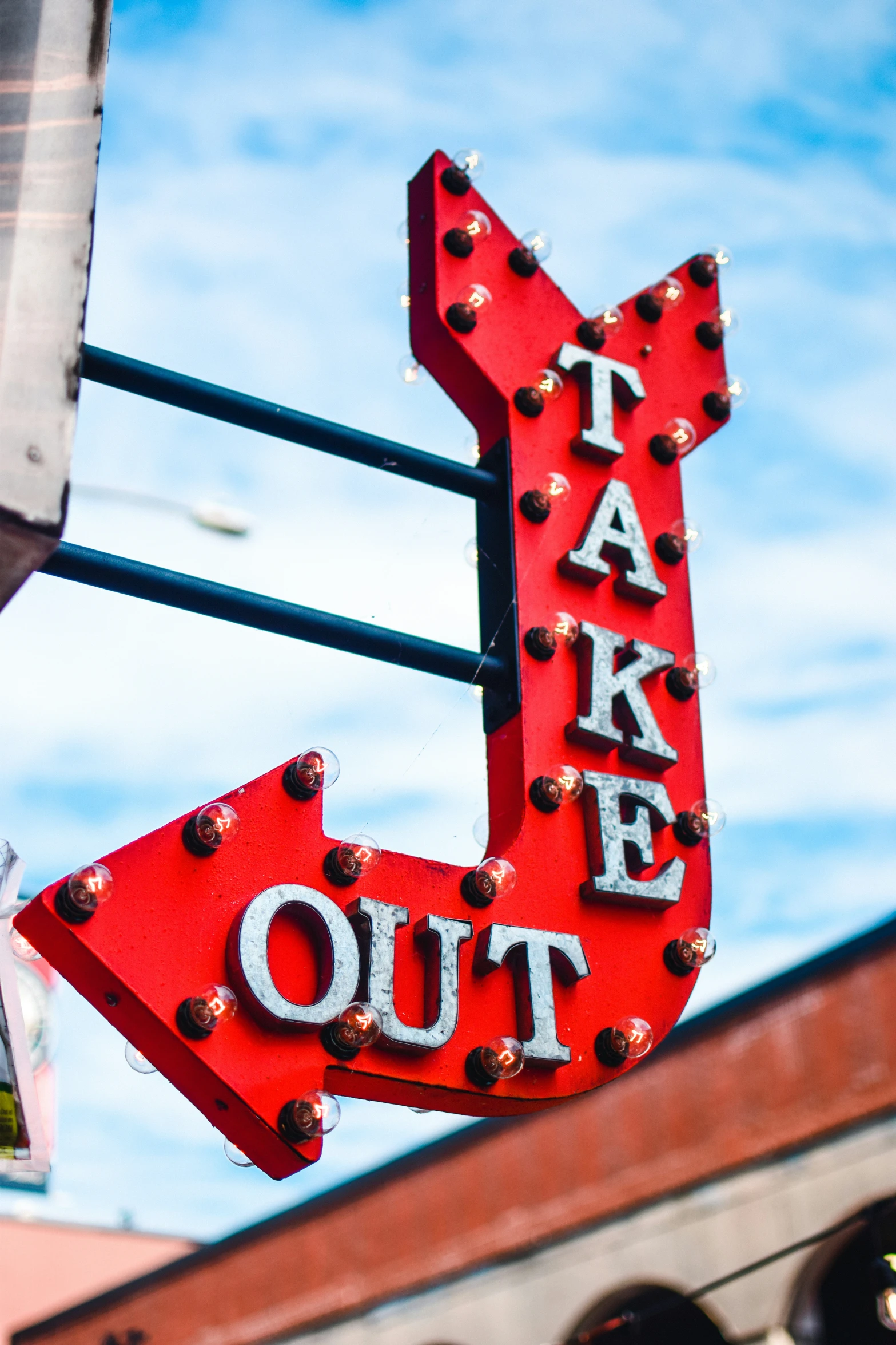 red take out sign hanging off the side of a building