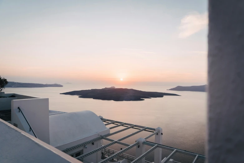 a sunset view with water and hills from the roof of a building