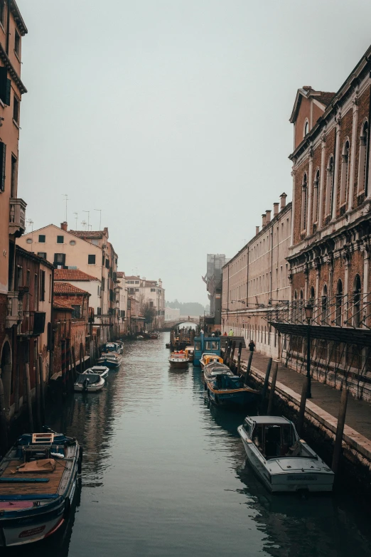 several boats are docked in a canal