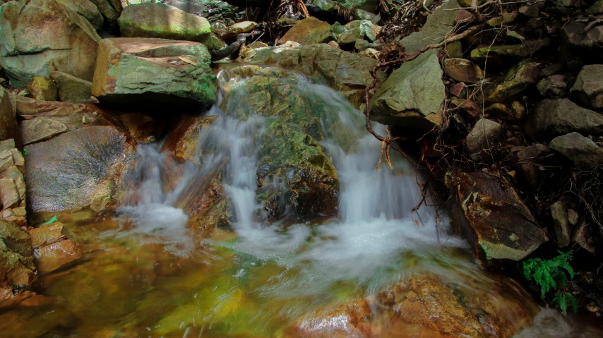 a waterfall cascading in to the rocks next to it