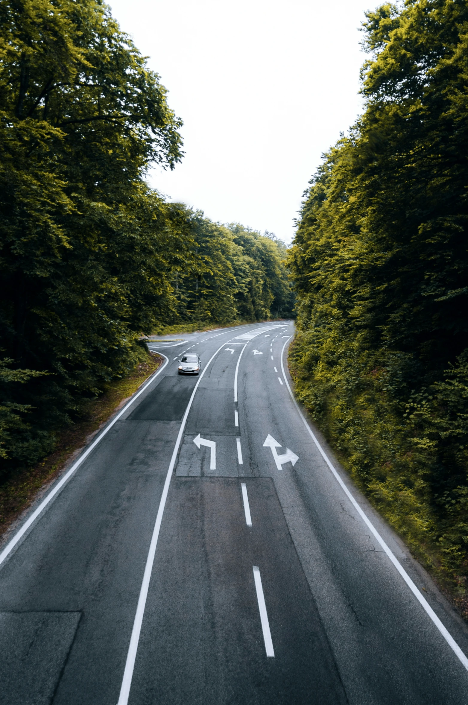 the car is driving down the empty road