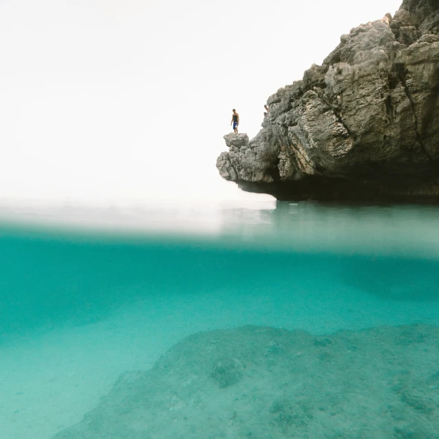 the small person is standing at the edge of the cliff