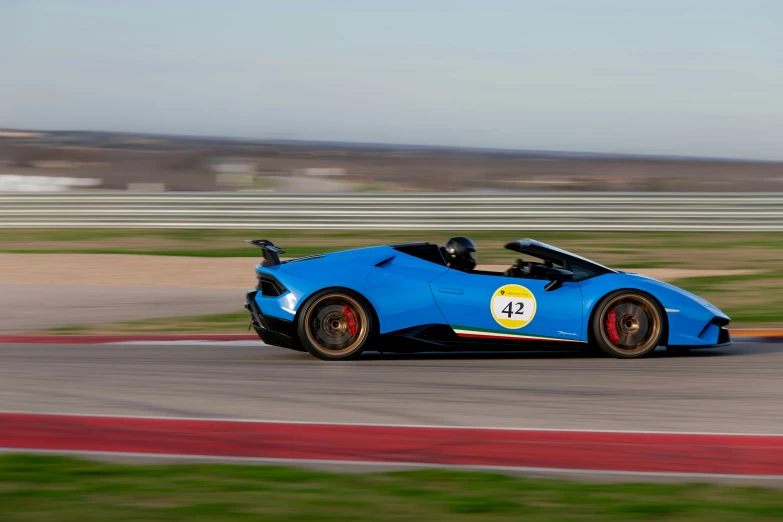 an automobile driving on the track with a lot of grass