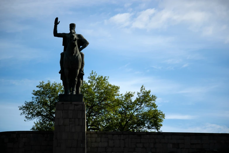 a statue of a man with a baseball bat on top of a block wall