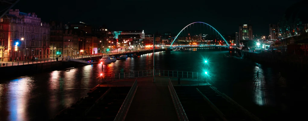 a large bridge is lit up in the dark