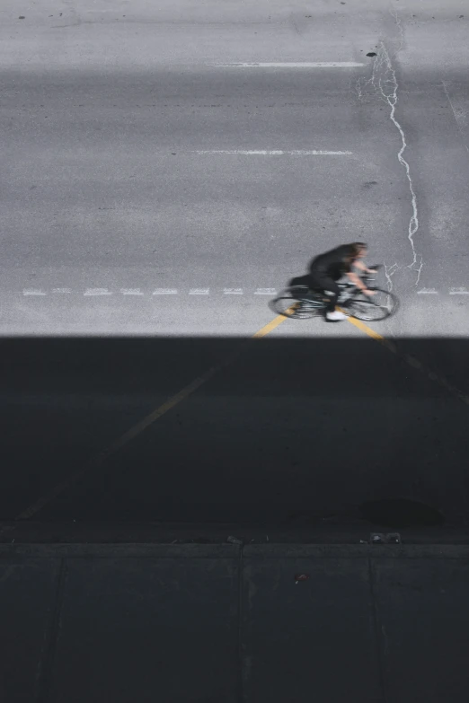 a man riding a bike next to an overpass