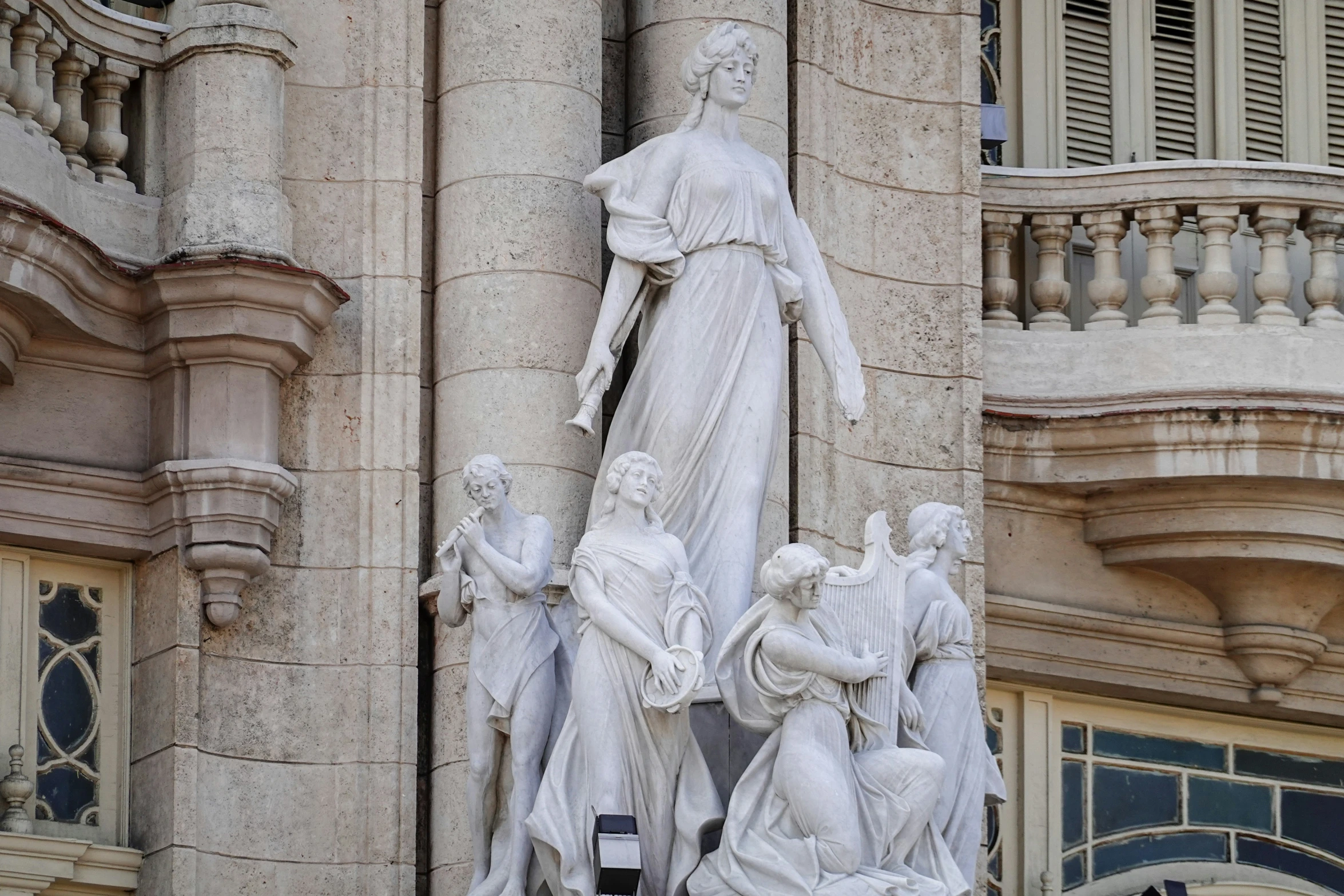 the statue is on the side of a tall building