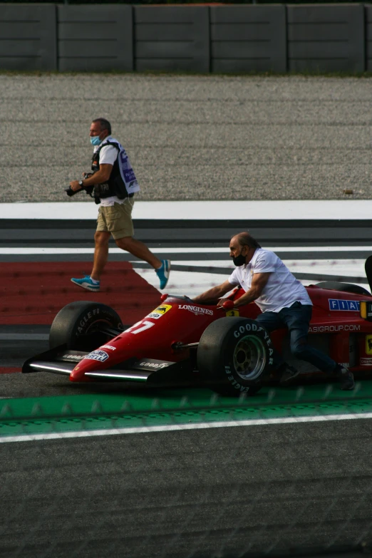 a person sits in the back of a racing car on a track