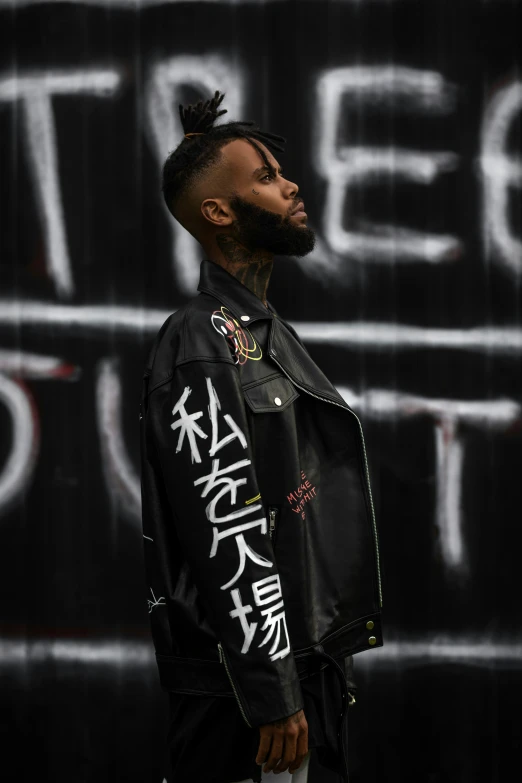 a man wearing an oriental tattoo and leather jacket