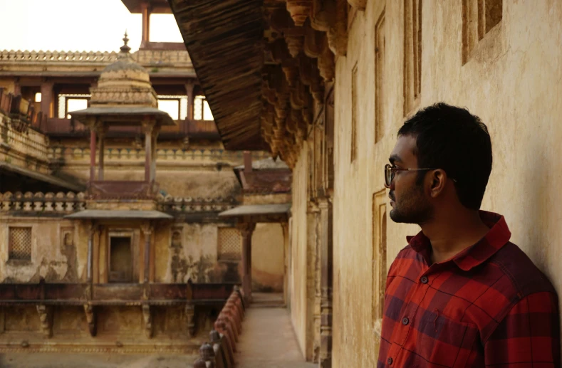 a man with a checkered red shirt looking back at the camera