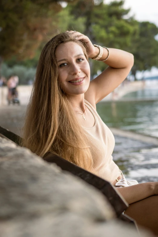 a smiling blonde girl leans against the edge of a rock