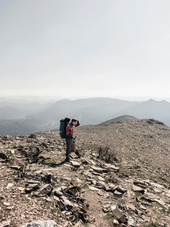 two people on a rocky hill taking pos